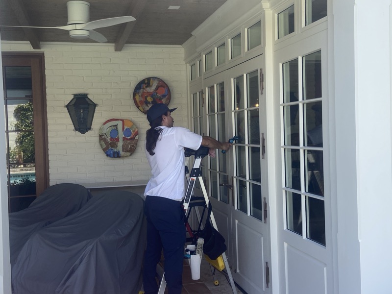 Technician detailing french doors at a Palm Beach property