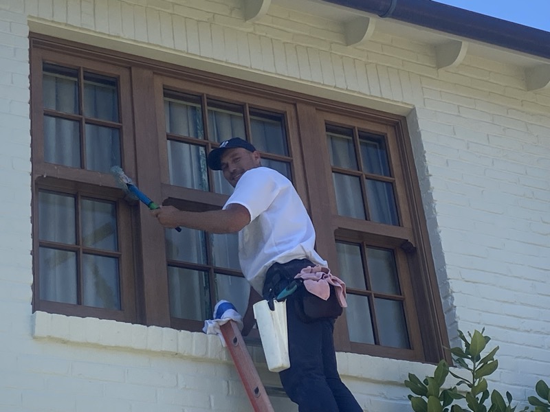 Technician with squeegee on ladder
